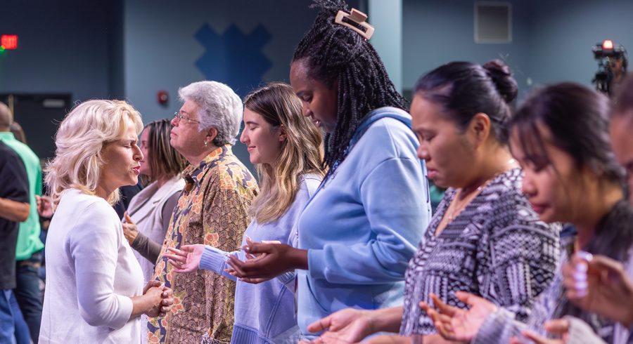 Believers praying with one another at the altar